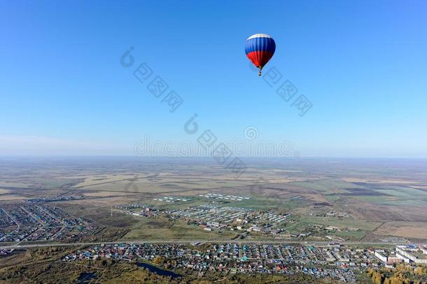 飞行关于热的天空气球越过乡下的风景