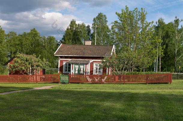 小的红色的小木屋和红色的罢工纠察员栅栏采用法格什塔,瑞典
