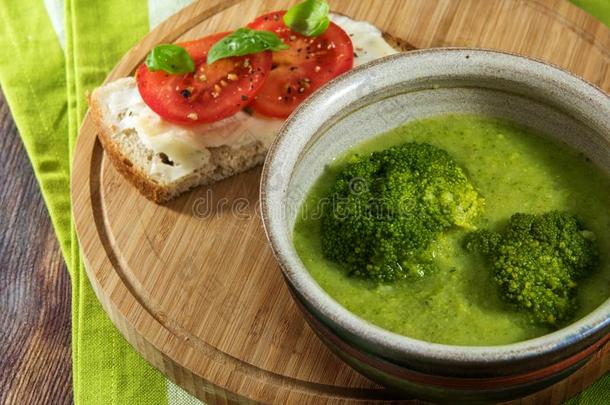 绿色的花椰菜蔬菜汤和面包和番茄向一乡村的