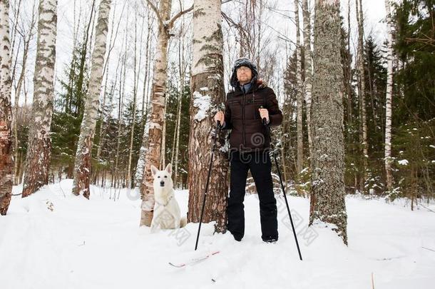 年幼的男人十字架-国家滑雪采用指已提到的人森林和白色的狗