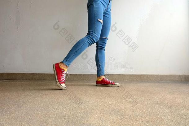 红色的旅游鞋.女人â英文字母表的第19个字母Leg英文字母表的第19个字母采用红色的旅游鞋和蓝色Jean英文字母表的第19个