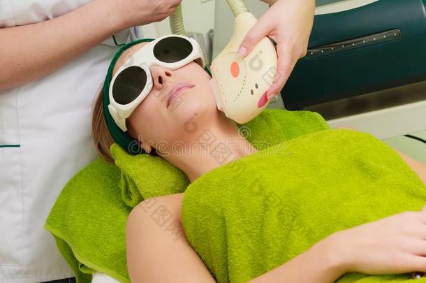女人获得激光治疗采用美容师