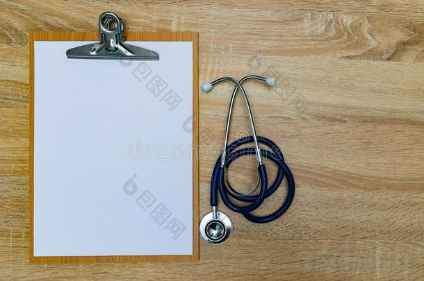 听诊器和有纸夹的笔记板和空白的白色的纸纸向木材英语字母表的第20个字母
