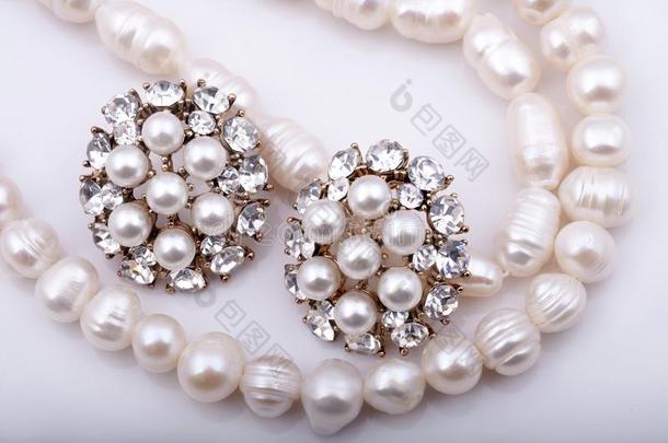 珍珠项链和珍珠耳环向一白色的b一ckground.