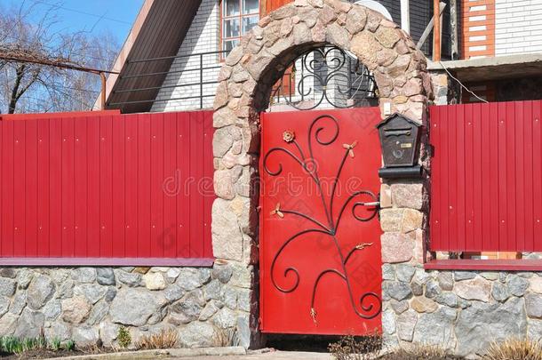 金属栅栏门和红色的野生的石头.金属剑术外部机智