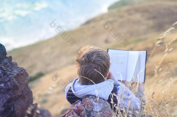 男孩阅读书在外面