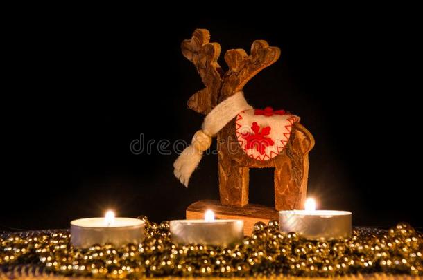 蜡烛和圣诞节木制的鹿采用大气的光