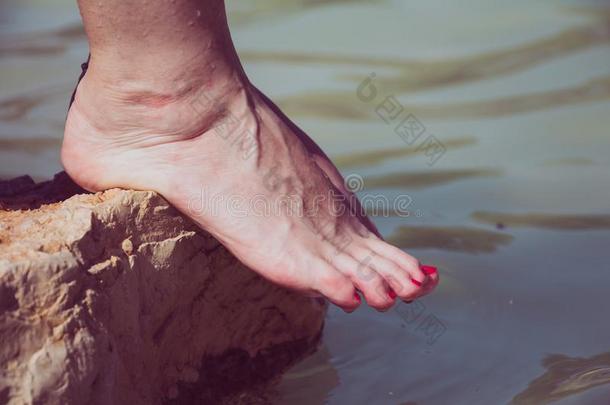 水滴从高加索人女人<strong>光秃秃</strong>的脚向一岩石边一t
