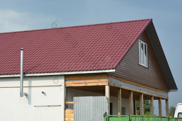 屋顶盖法建筑物和红色的金属屋顶瓦片和金属烟囱