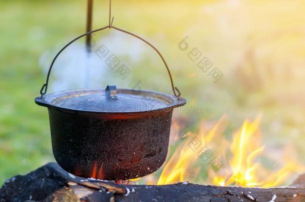 野营厨房用具-罐向指已提到的人火在一户外的野营地