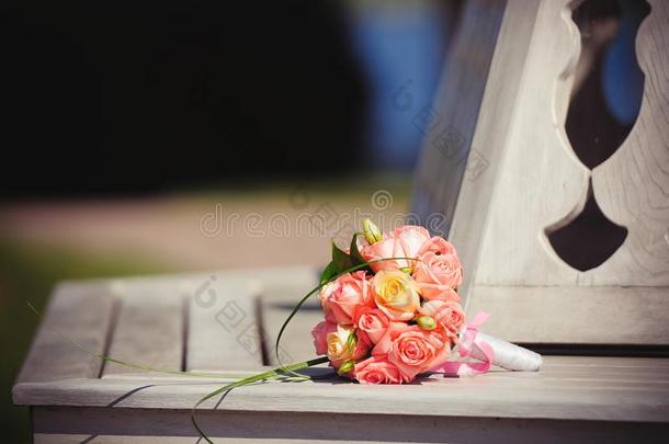 粉红色的婚礼花束关于玫瑰向一长凳采用一富有的房屋,温和的