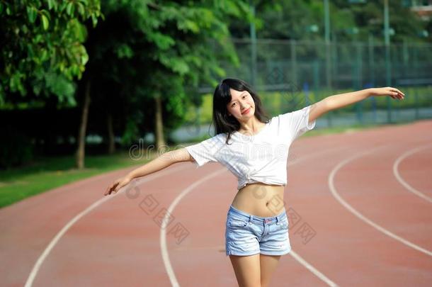 亚洲人女孩向跑道采用学校操场
