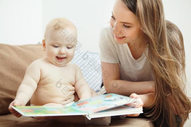 母亲阅读向小的婴儿富有色彩的书和仙女候补陪审员召集令.
