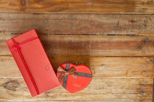 红色的赠品盒和红色的带和袖珍型的东西心里面的向木材后面
