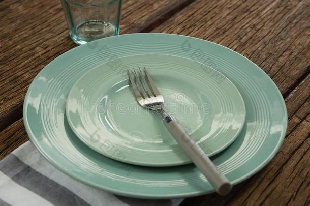 盘子和餐叉和餐巾向木制的表