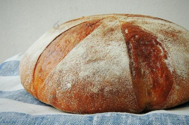 新鲜的一条面包关于面包向手工做的有条纹的亚麻布毛巾.