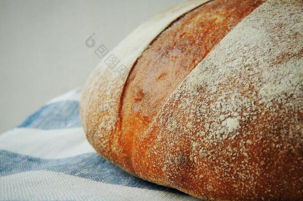 新鲜的一条面包关于面包向手工做的有<strong>条纹</strong>的亚<strong>麻布</strong>毛巾.