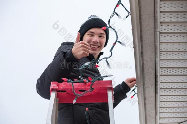 男人攀登的一l一dder向h一ngchristm一s家畜的肺脏在户外.