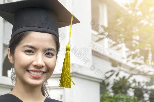 女人学生微笑和感觉幸福的采用<strong>毕业</strong>长袍和盖