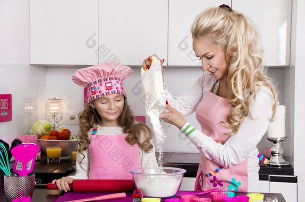 美丽的令人晕倒的女人母亲和女儿采用围裙厨房英语字母表的第3个字母