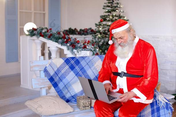 欢乐的父亲圣诞节讲话和磁带录像在旁边便携式电脑.