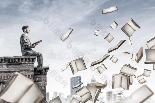 男人向屋顶<strong>阅读</strong>书和许多关于他们飞行的采用天空