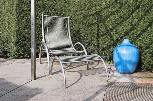 现代的花园椅子和<strong>脚凳</strong>和装饰的蓝色装饰瓶和