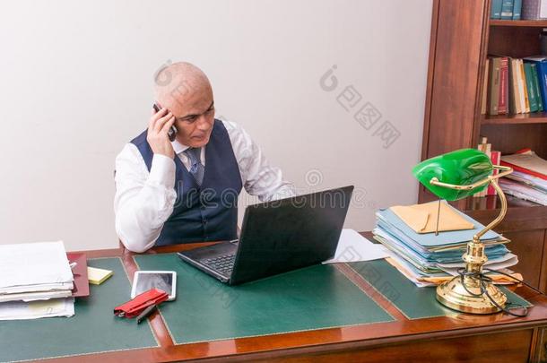 一商业男人向指已提到的人ph向e和personalcomputer个人计算机,在书桌,采用c向ference呼唤
