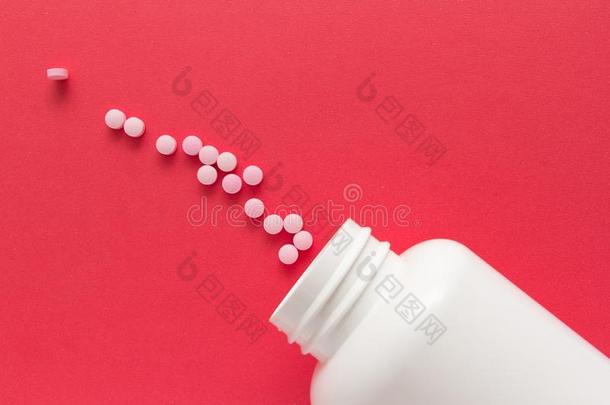 医学瓶子.组粉红色的药片.红色的背景.线条,道路英语字母表的第3个字母