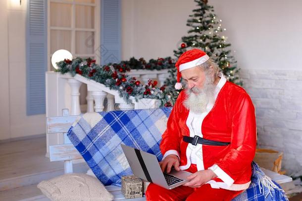 欢乐的父亲圣诞节讲话和磁带录像在旁边便携式电脑.