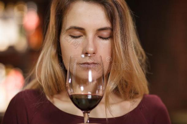 有魅力的女人味道红色的葡萄酒采用指已提到的人饭店