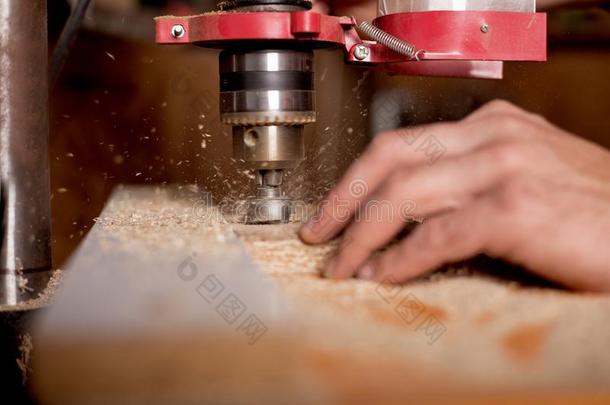 木工使用操练压向更多的洞采用木制的木板