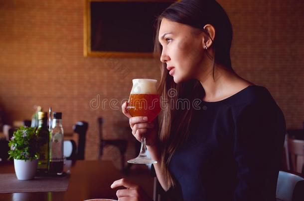 黑头发的妇女喝饮料一啤酒采用一rest一ur一nt
