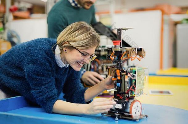 年幼的女人工程师工作的向机器人技术放映