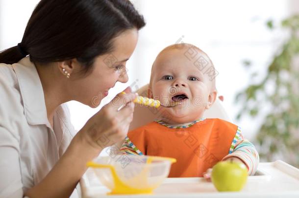 母亲给食她婴儿和勺.母亲礼物健康的食物英语字母表的第20个字母