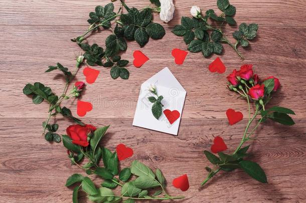 框架关于红色的玫瑰和绿色的树叶和红色的心向一木制的