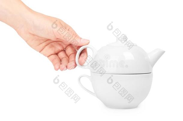 白色的陶器的壶或茶壶和杯子采用手.隔离的向whiteiron白铁