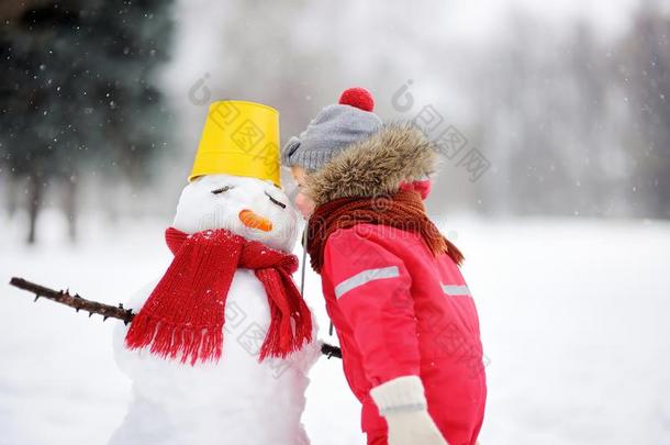 小的男孩告诉雪人关于他的秘密或礼物f或圣诞节