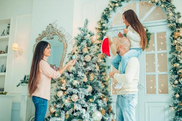 漂亮的女孩和她mot她装饰枞树向圣诞节前夕