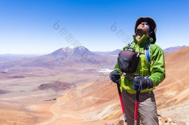 旅行者男人探险家背着背包徒步旅行的人起立山山峰,玻利维亚