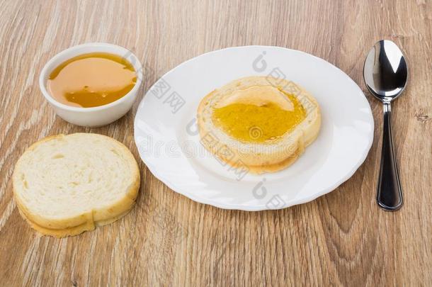 面包和蜂蜜采用盘子,茶匙,碗和蜂蜜