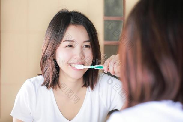 年幼的女人疾驰的她牙在镜子.后的觉醒中的