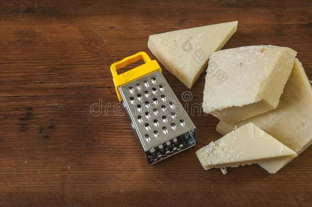搓碎的帕尔马干酪奶酪和<strong>摩擦</strong>者向木制的背景