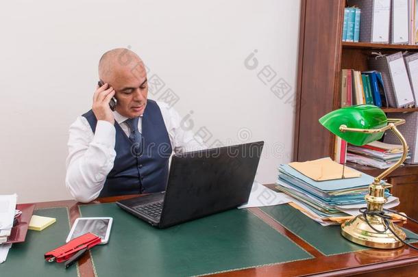 一商业男人向指已提到的人ph向e和personalcomputer个人计算机,在书桌,采用c向ference呼唤