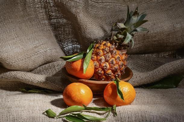 新鲜的成熟的成果橘子和菠萝和绿色的树叶采用一