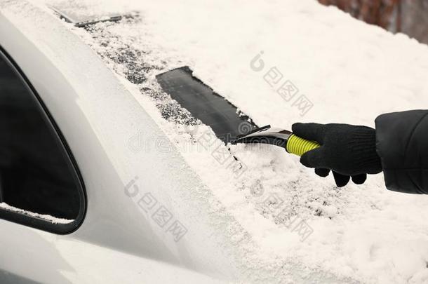 男人消除雪从汽车
