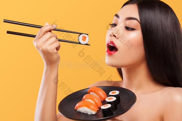 特写镜头肖像关于亚洲人女人吃寿司和名册向一叫喊