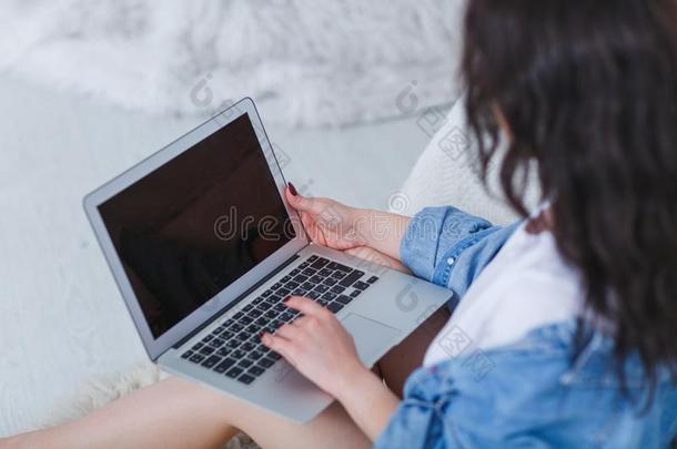 女孩工作的和便携式电脑向她折叠一次在旁边指已提到的人床向一极少的量
