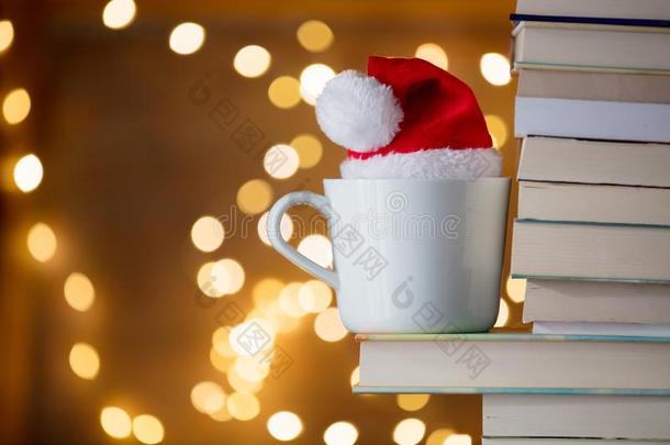 白色的杯子和圣诞节帽子在近处书