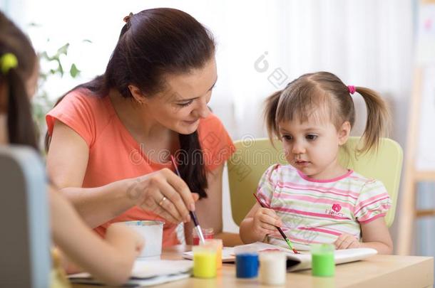女人教小孩绘画在幼儿园或幼儿游戏组